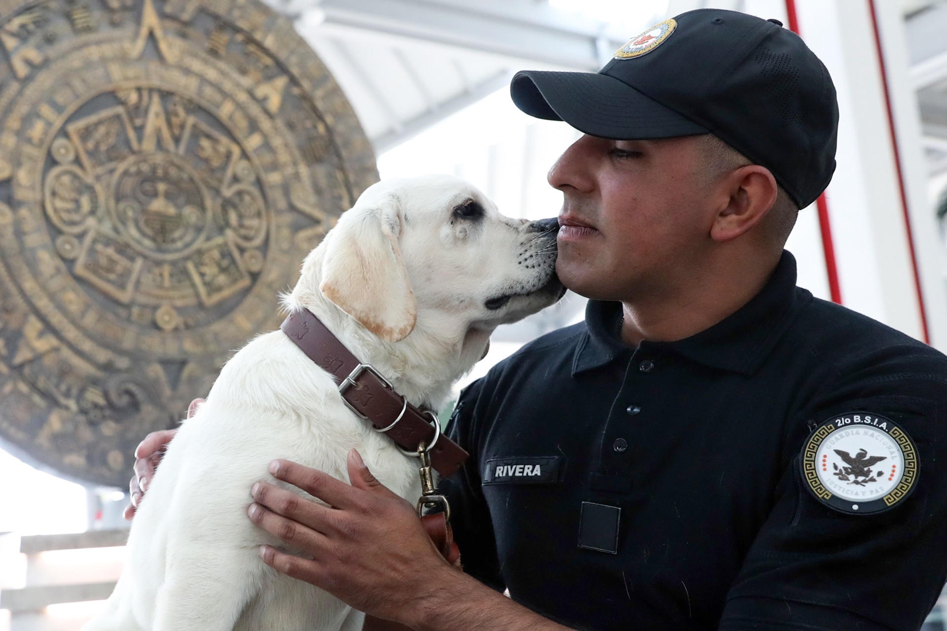 Un integrante de la Guardia Nacional posa junto a un perro del 'Escuadrón Canino' este lunes, en el Aeropuerto Internacional Felipe Ángeles (AIFA) en Santa Lucía (México). EFE/Mario Guzmán