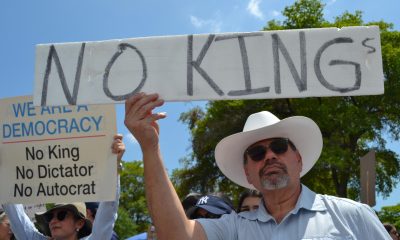 Personas se manifiestan sosteniendo carteles durante la protesta 'No Kings' (No queremos reyes) este sábado, en Miami (Estados Unidos). EFE/ Antoni Belchi