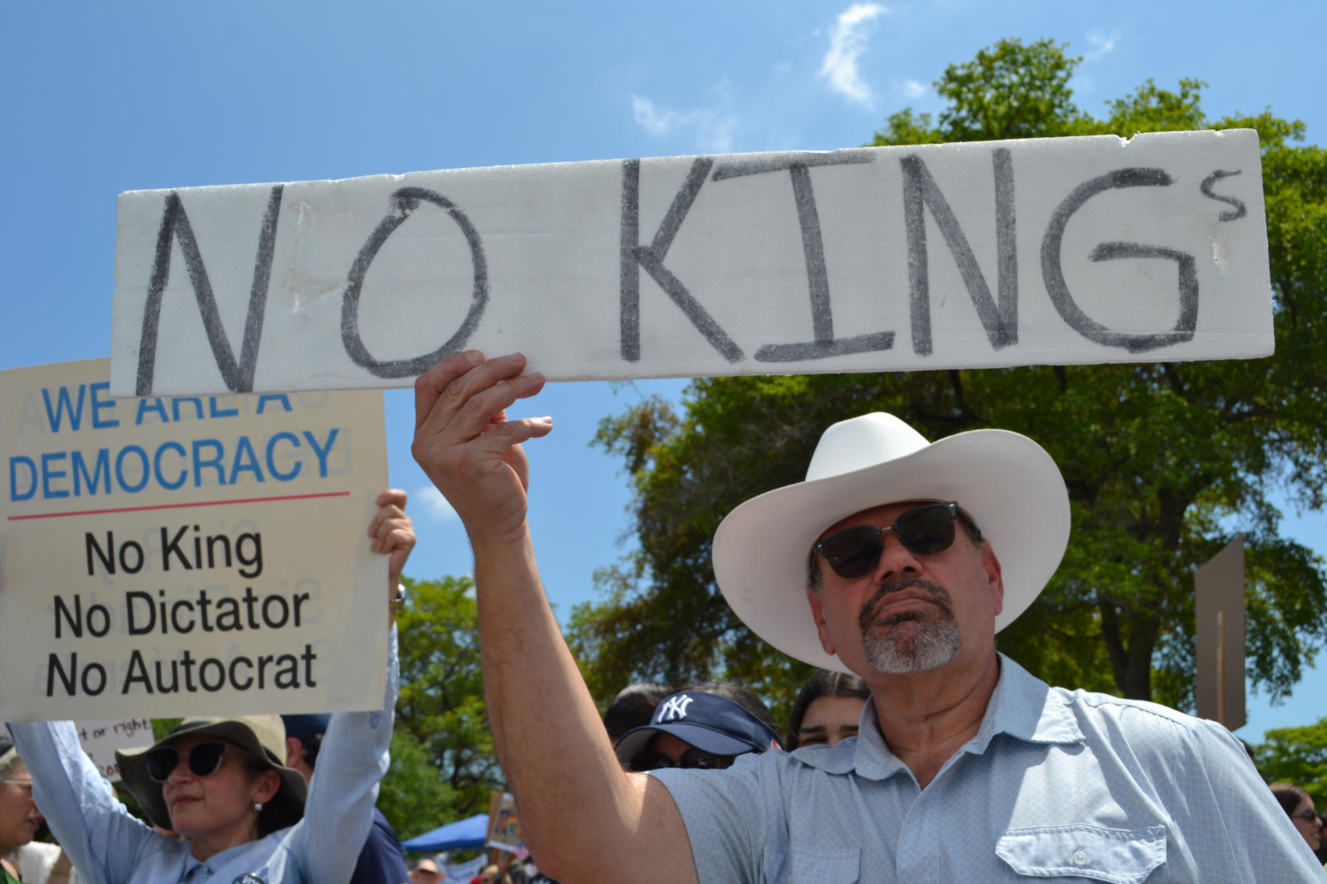 Personas se manifiestan sosteniendo carteles durante la protesta 'No Kings' (No queremos reyes) este sábado, en Miami (Estados Unidos). EFE/ Antoni Belchi