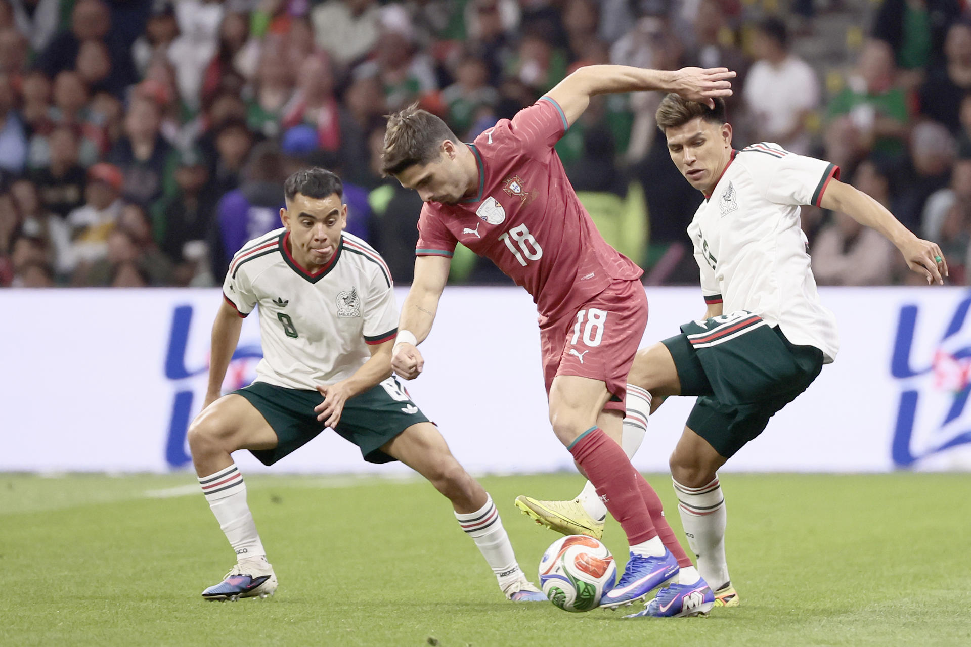 Carlos Rodríguez (i), de México, disputa un balón con Pedro Neto (c), de Portugal, durante el amistoso en el remodelado estadio Azteca, ahora llamado Banorte, de Ciudad de México. EFE/José Méndez