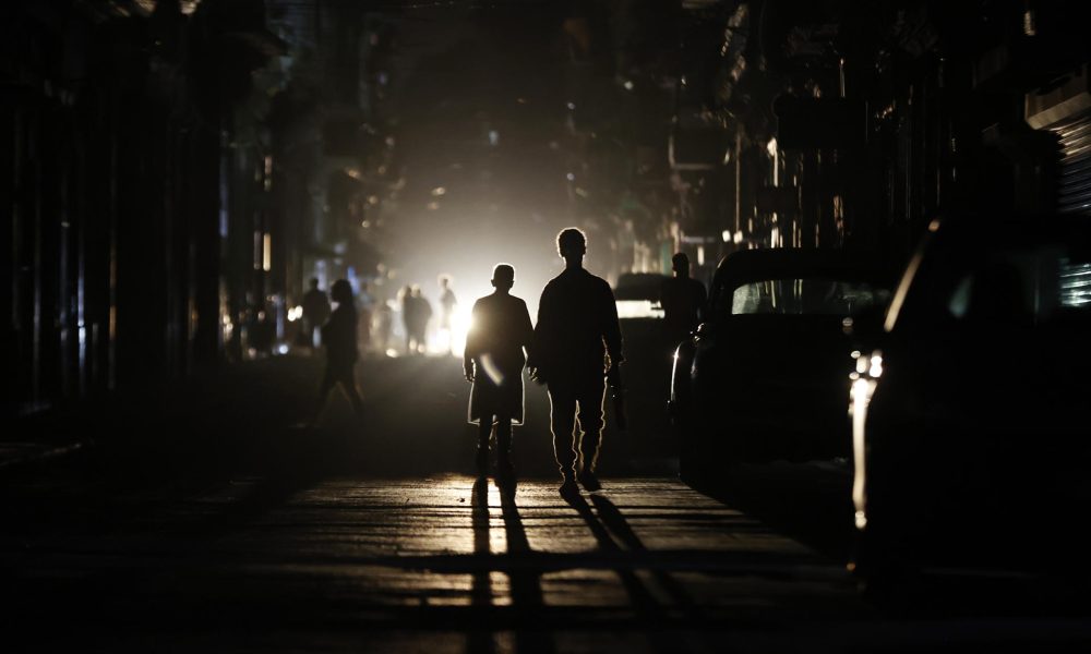 Personas caminan por una calle sin electricidad este sábado, en La Habana (Cuba). EFE/ Ernesto Mastrascusa