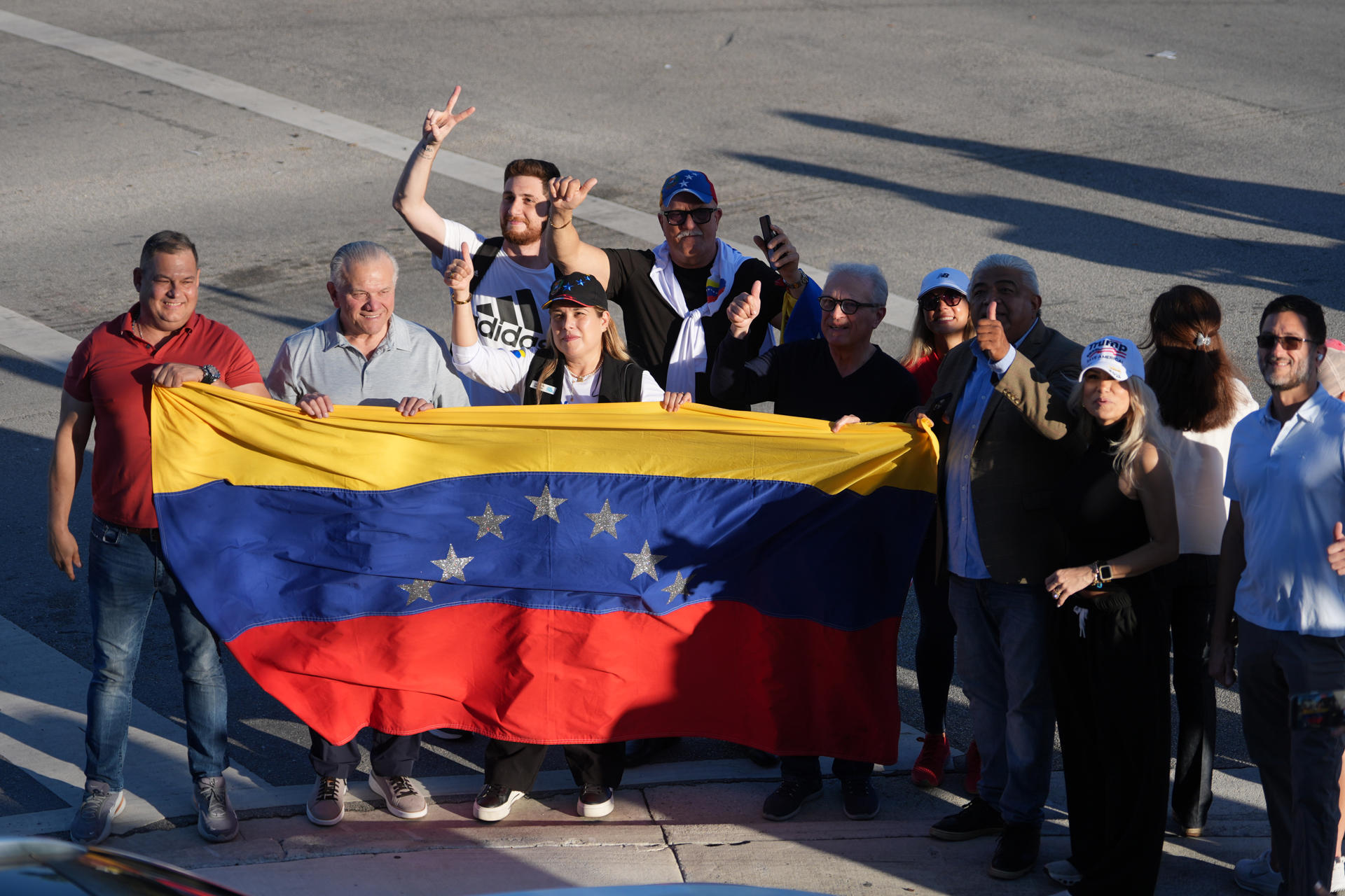 Ciudadanos venezolanos sostienen una bandera de su país esperando la llegada del presidente de Estados Unidos, Donald Trump, al restaurante venezolano El Arepazo este lunes, en Doral, aproximadamente a 14-15 millas de Miami (Estados Unidos). EFE/Alberto Boal