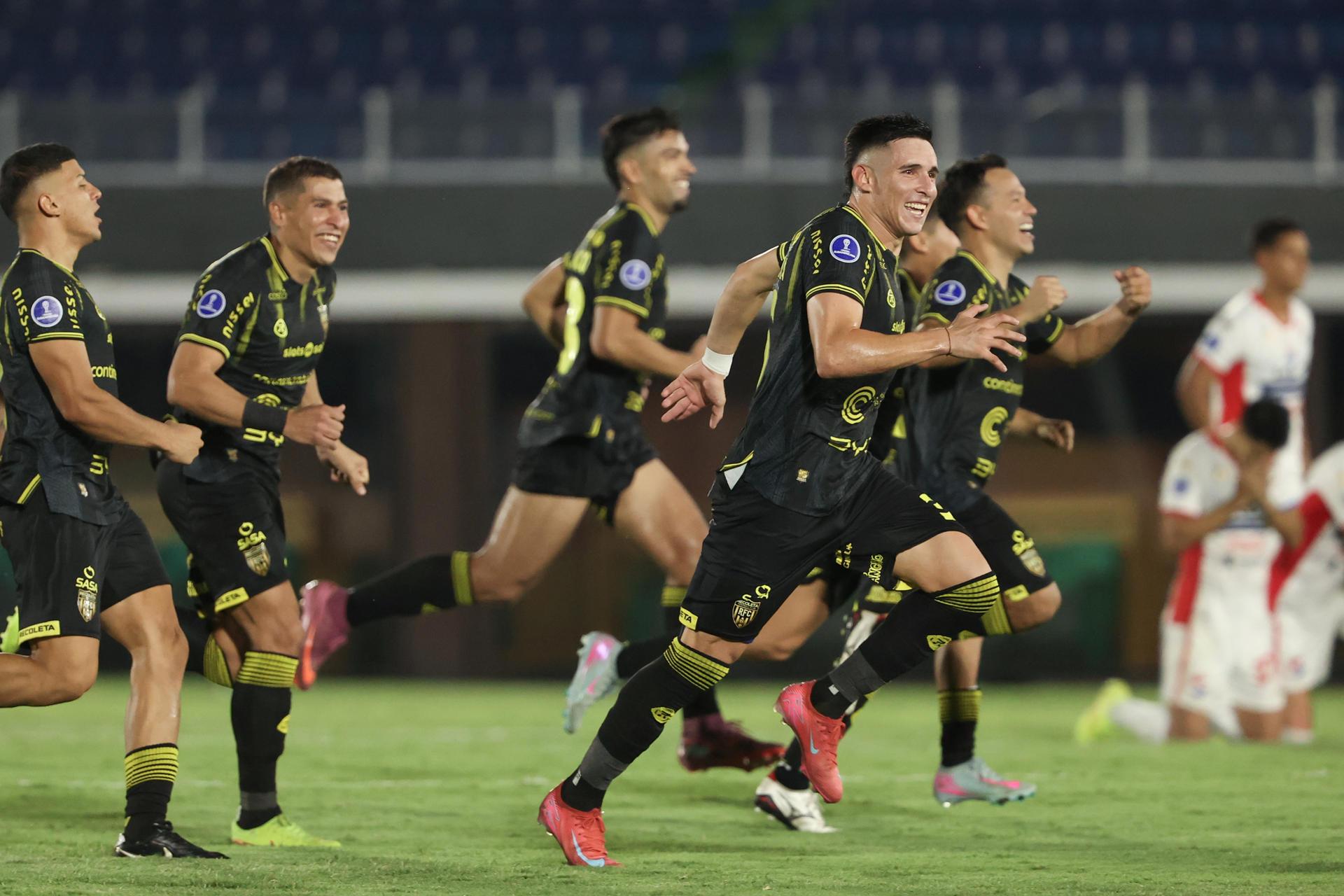 Jugadores del Recoleta celebran este jueves la clasificación a la fase de grupos de la Copa Sudamericana al vencer en la tanda de penaltis al Nacional en el duelo de la fase previa entre equipos paraguayos. EFE/ Juan Pablo Pino