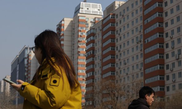 PEKÍN (China), 16/03/2026.- Varias personas caminan junto a edificios de viviendas en Pekín, China. EFE/EPA/JESSICA LEE