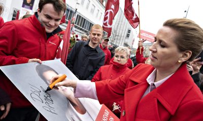 La primera ministra de Dinamarca y líder de los socialdemócratas, Mette Frederiksen (d), firma un cartel electoral mientras se reúne con votantes el día de las elecciones, en la plaza Nytorv, en Aalborg, Dinamarca, el 24 de marzo de 2026. EFE/EPA/HENNING BAGGER DENMARK OUT