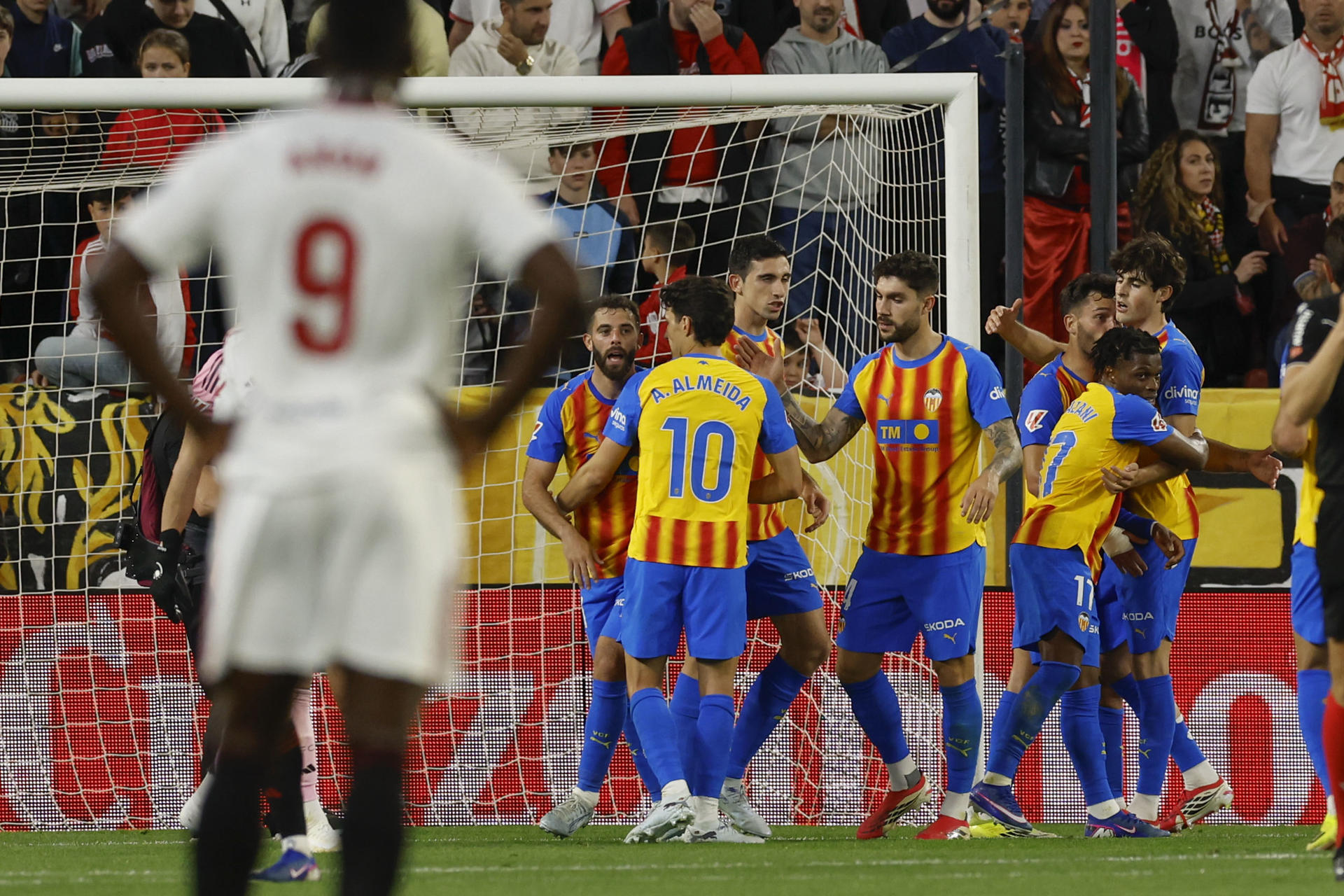 -Los jugadores del Valencia celebran el gol del centrocampista del Valencia Largie Ramazani contra el Sevilla, durante el partido de la jornada 29 de LaLiga EA Sports entre Sevilla y Valencia, este sábado en el estadio Sánchez- Pizjuán en Sevilla.-EFE/ Julio Muñoz