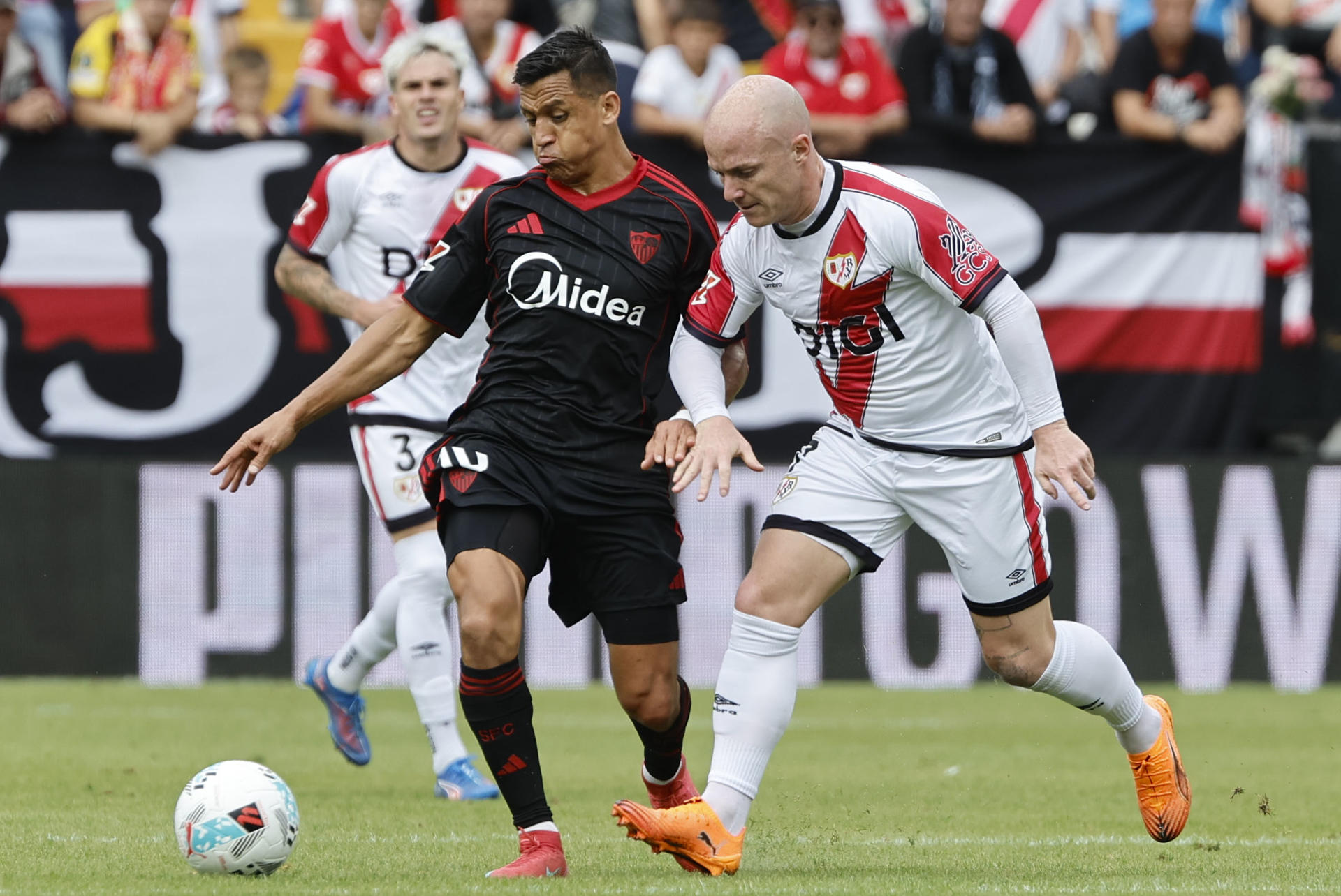 Alexis Sánchez (i), del Sevilla, disputa el balón Isi Palazón, del Rayo Vallecano, durante el partido de la jornada 7 de LaLiga disputado el 28 de septiembre en el Estadio de Vallecas. EFE/ Sergio Pérez