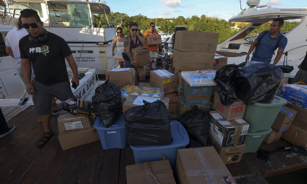 Personas cargan paquetes con ayuda humanitaria para un barco que zarpará hacia Cuba desde Isla Mujeres, en Quintana Roo (México). EFE/ Alonso Cupul