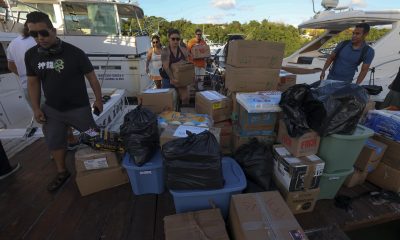 Personas cargan paquetes con ayuda humanitaria para un barco que zarpará hacia Cuba desde Isla Mujeres, en Quintana Roo (México). EFE/ Alonso Cupul