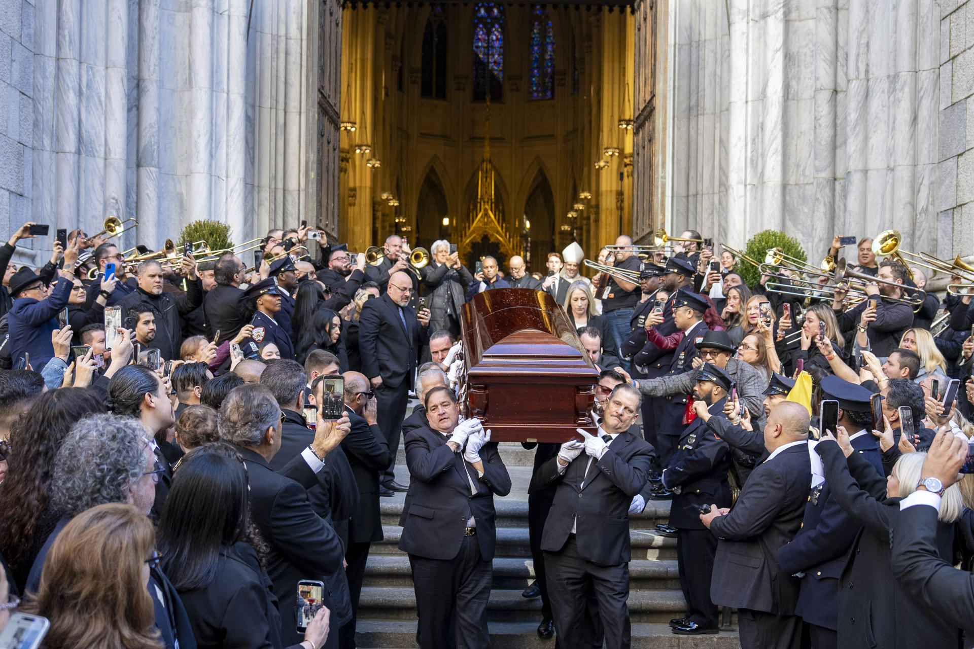 Personas sostienen el féretro del cantante Willie Colón este lunes, al finalizar una misa pública en la Catedral de San Patricio en Nueva York (Estados Unidos). EFE/ Ángel Colmenares