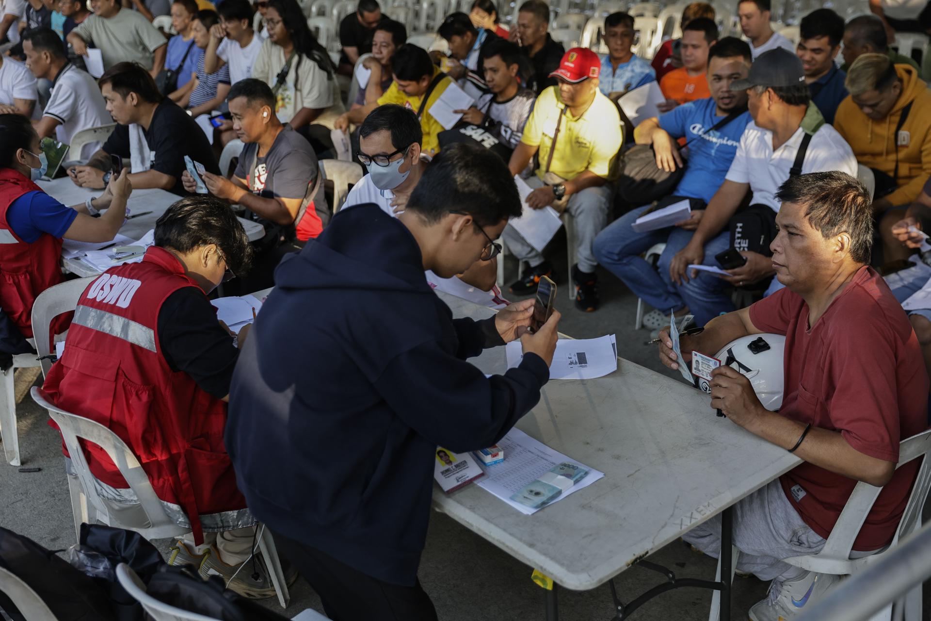 CIUDAD QUEZON (Filipinas), 24/03/2026.- Conductores de servicios de transporte de Filipinas reciben un subsidio gubernamental distribuido en un parque público de Ciudad Quezón, en Metro Manila, como parte de las medidas de ayuda del gobierno ante el aumento del precio del combustible provocado por el conflicto en Oriente Medio. EFE/EPA/ROLEX DELA PENA