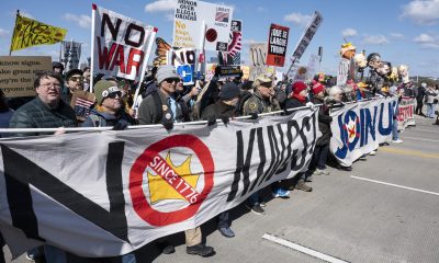 Activistas sostienen carteles y pancartas mientras participan en la marcha 'No Kings' (No reyes) en Washington. EFE/Luke Johnson
