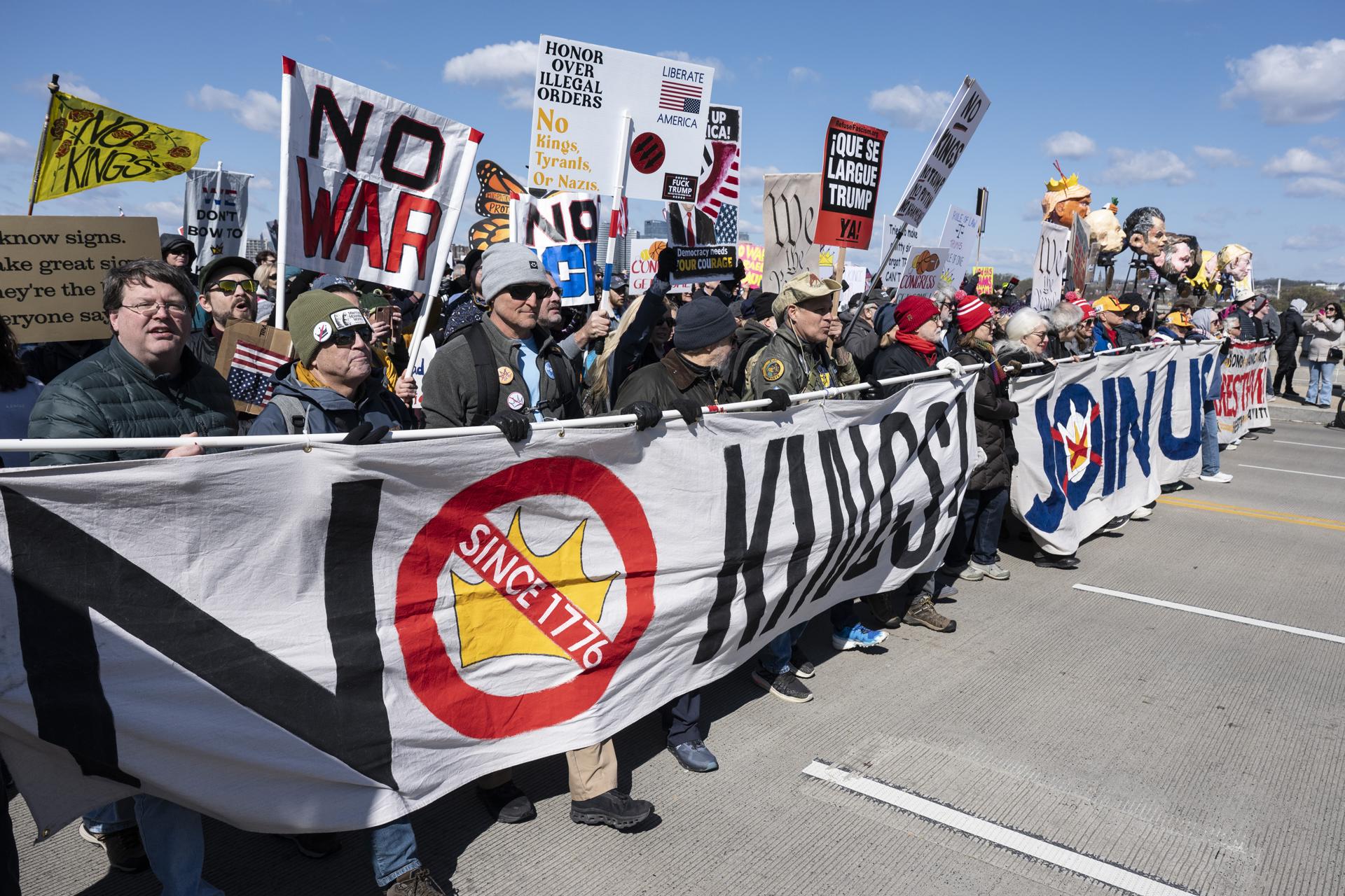 Activistas sostienen carteles y pancartas mientras participan en la marcha 'No Kings' (No reyes) en Washington. EFE/Luke Johnson