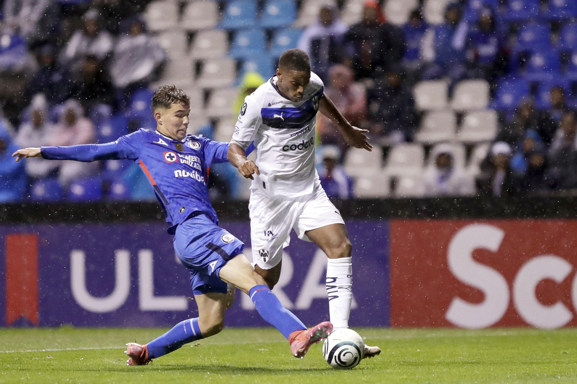 Agustín Palavecino (i) de Cruz Azul disputa el balón con Anthony Martial (d) de Monterrey durante el juego que clasificó este martes al equipo celeste a los cuartos de final de la Liga de Campeones de la Concacaf en el estadio Cuauhtémoc de Puebla. EFE/Hilda ríos