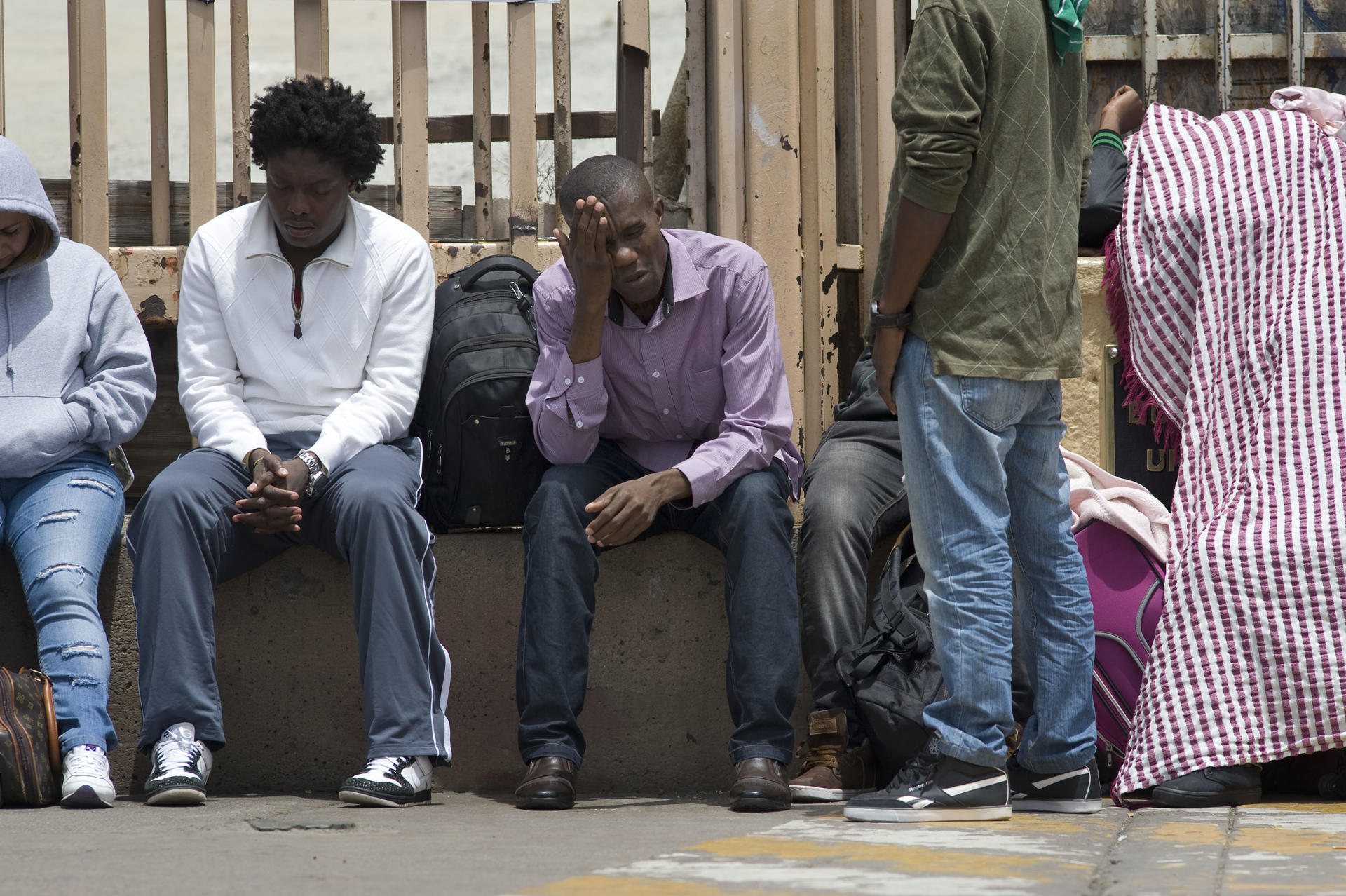 Fotografía de archivo en donde se observa a inmigrantes esperando en la frontera entre México y Estados Unidos. EFE/DAVID MAUNG