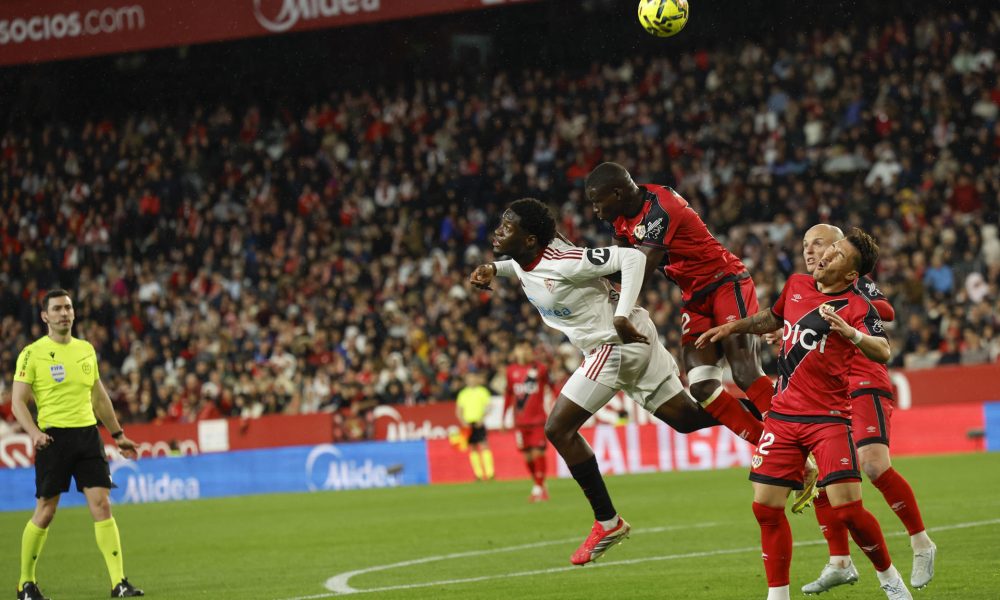 El defensa senegalés del Rayo Nobel Mendy (2i) pelea un balón aéreo con el delantero nigeriano Akor Adams (i), del Sevilla, durante el partido de la jornada 27 de LaLiga que Sevilla FC y Rayo Vallecano disputaron en el estadio Ramón Sánchez-Pizjuán. EFE/Julio Muñoz