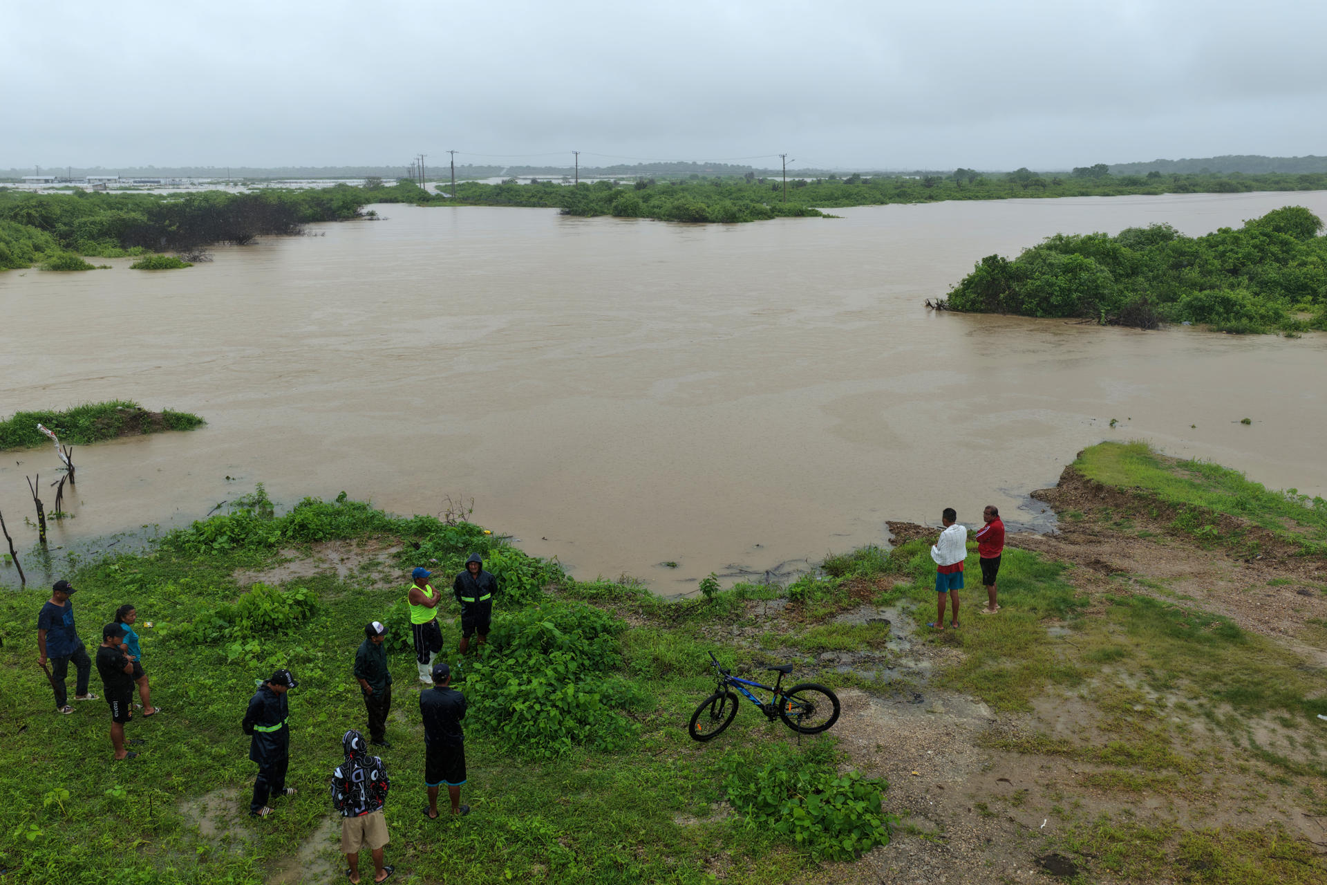 Fotografía aérea que muestra a personas observando las inundación este 4 de marzo de 2026, en la localidad de Chanduy en Santa Elena (Ecuador). EFE/ Gerardo Menoscal