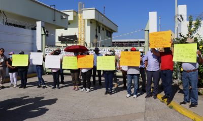 Trabajadores de Petróleos Mexicanos (Pemex) sostienen carteles durante un bloqueo esta lunes, en las instalaciones de Puerto Chiapas en Tapachula (México). EFE/ Juan Manuel Blanco