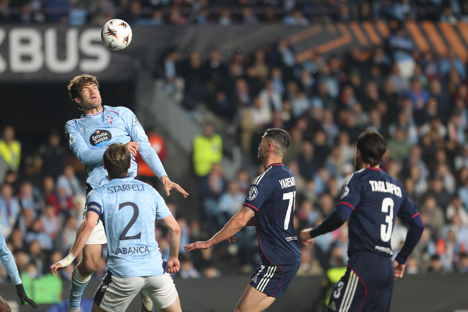 El defensa del Celta Marcos Alonso (i) cabecea un balón ante Roman Yaremchuk (2-d), del Olympique, en la ida jugada en el estadio de Balaídos, en Vigo. EFE/Salvador Sas