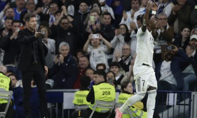 El delantero del Real Madrid Vinicius Junior (d) abandona el terreno de juega ante el técnico Diego Simeone, del Atlético, durante el partido de la jornada 29 de LaLiga que Real Madrid y Atlético de Madrid han disputado este domingo en el estadio Santiago Bernabéu. EFE/Juanjo Martín