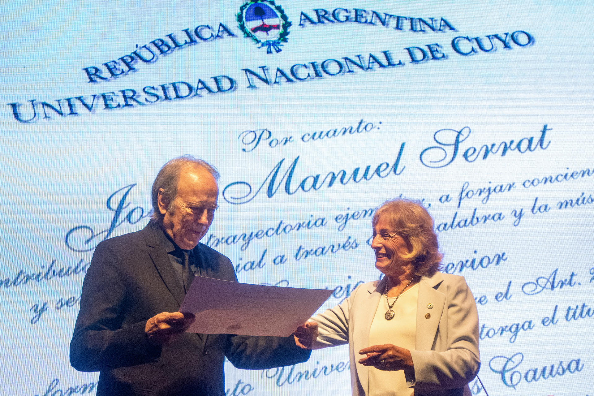 El cantautor catalán Joan Manuel Serrat (i) recibe de la rectora de la Universidad Nacional de Cuyo, Esther Sánchez, el doctor Honoris Causa concedido por la Universidad Nacional de Cuyo este viernes, en Mendoza (Argentina). EFE/ Ramiro Gómez
