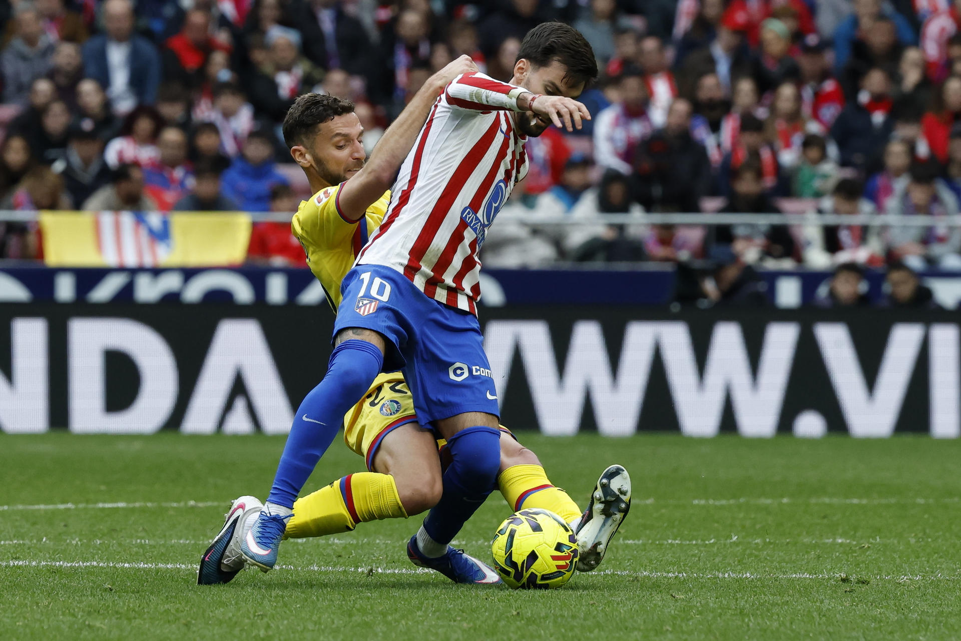 El centrocampista del Atlético de Madrid Álex Baena (d) pelea un balón ante el defensa portugués del Getafe Domingos Duarte durante el partido de LaLiga disputado el sábado. EFE/ J.J.Guillen
