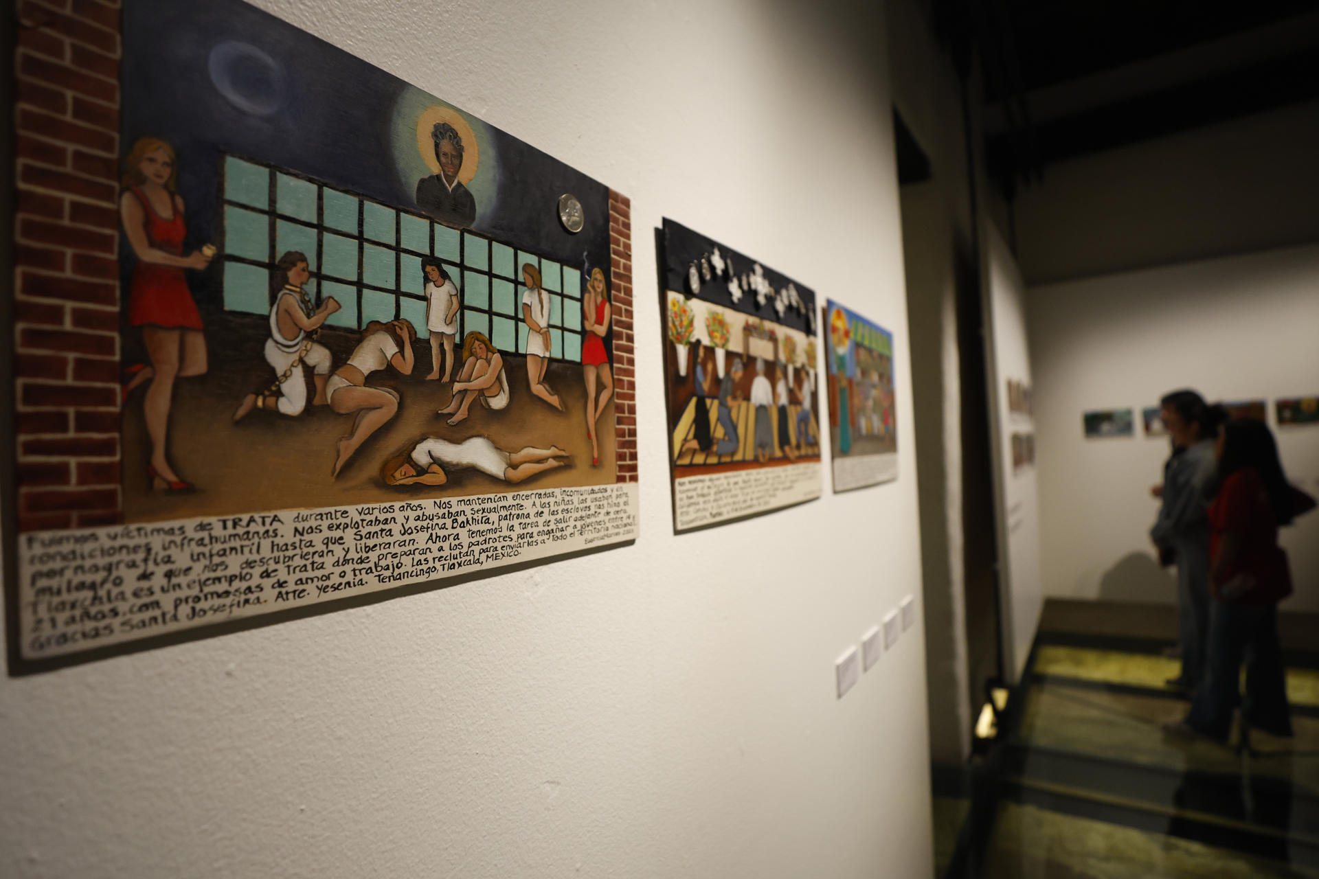 Personas observan obras de la exposición 'Niñas vendidas' de la pintora mexicana Eugenia Marcos, este jueves en el Claustro de Sor Juana en Ciudad de México (México). EFE/ Sáshenka Gutiérrez