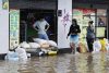 Personas usan sacos de arena para impedir que el agua entre a las casas debido a las inundaciones por fuertes lluvias este jueves, en Facatativá (Colombia). EFE/ Mauricio Dueñas Castañeda
