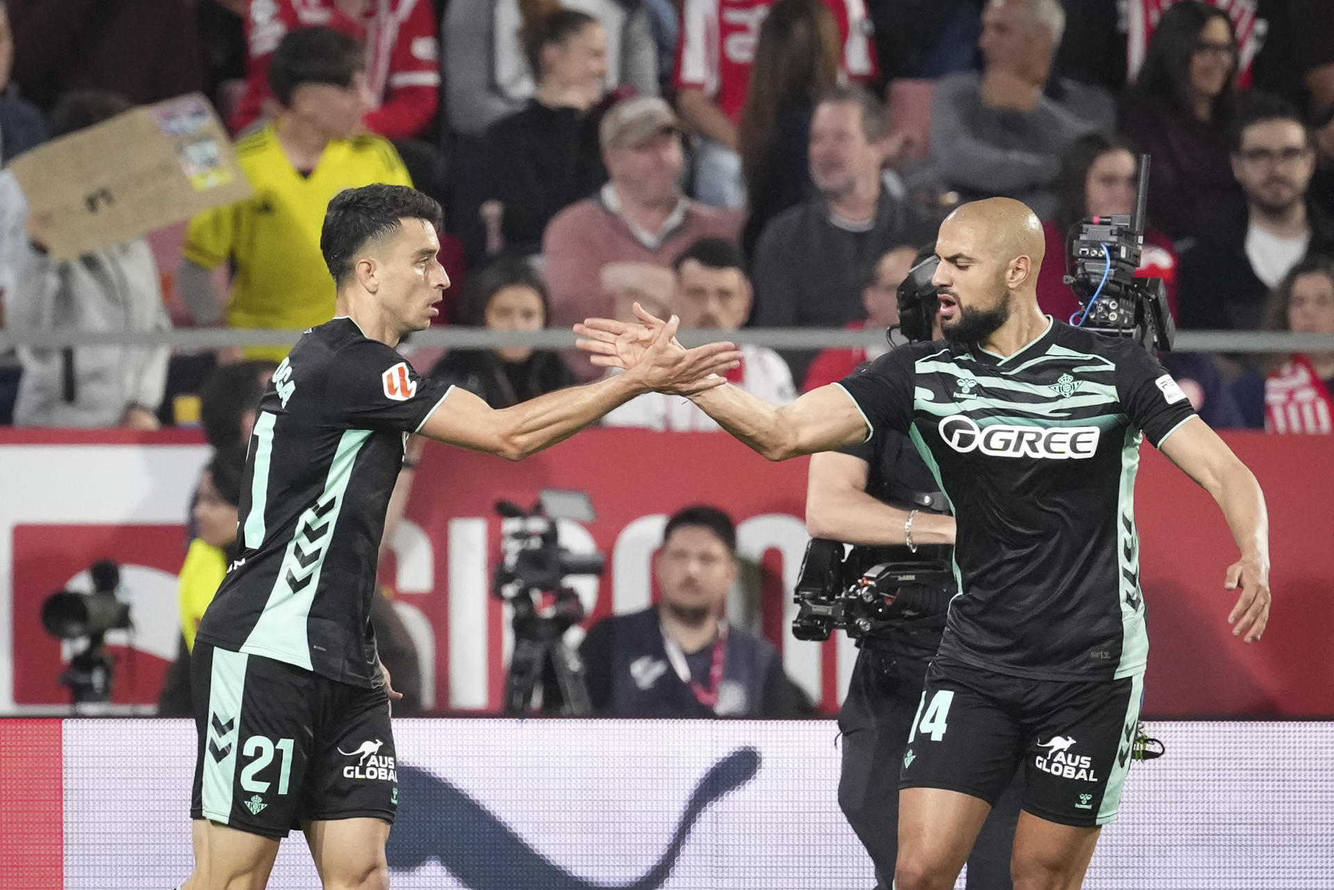 El centrocampista del Betis Marc Roca (i) celebra tras anotar el primer gol del equipo este martes, durante el partido de la jornada 33 de LaLiga EA Sports que disputan el Girona FC y el Real Betis en el Estadio Montilivi. EFE/ David Borrat