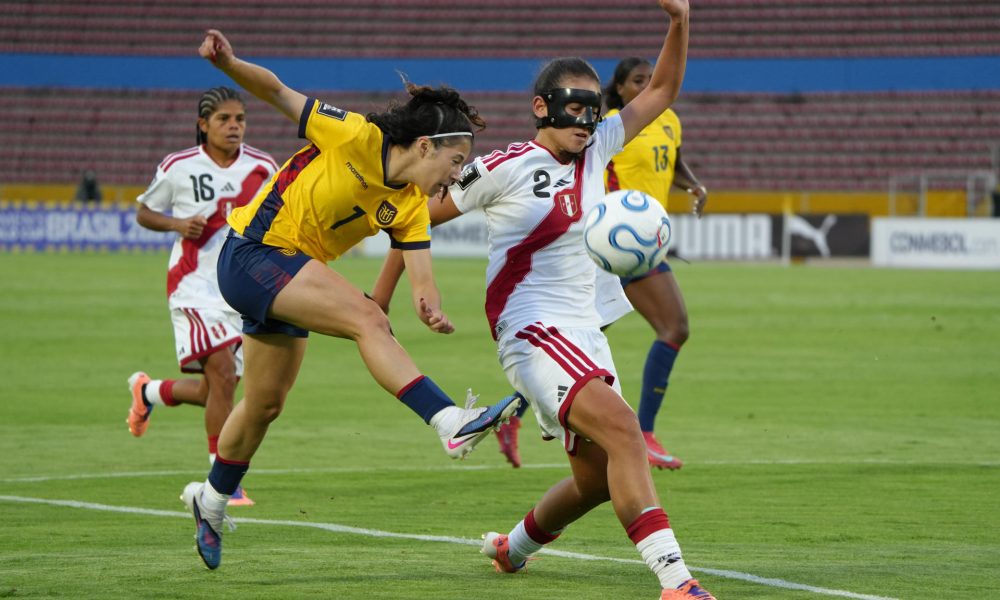 La ecuatoriana Emily Arias (i) prueba con un remate a la portería de Perú ante la marca de Luana Chamochumbi en el partido de la Liga de Naciones jugado este sábado en el estadio Olímpico Atahualpa en Quito. EFE/ Vicente Costales