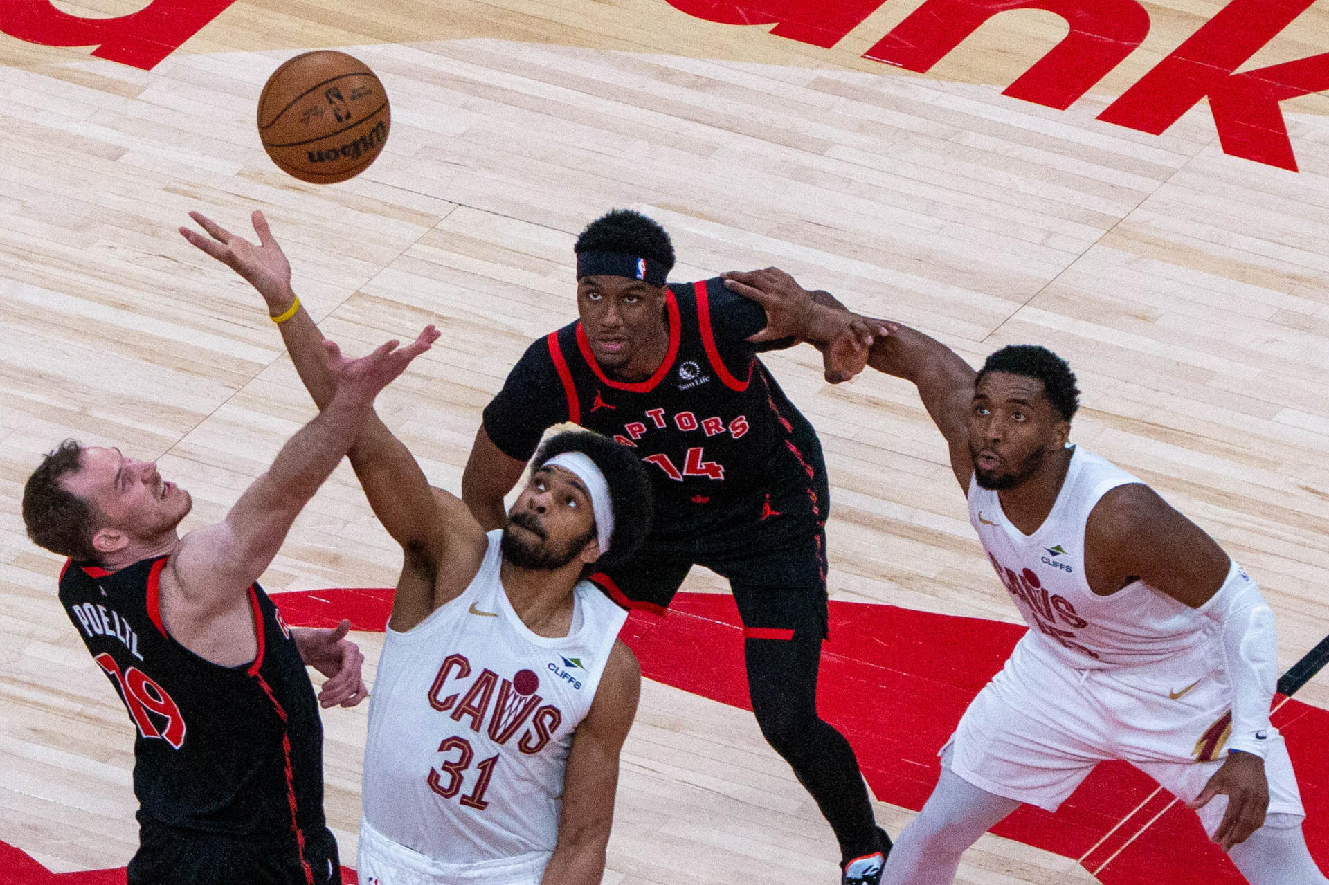 Jakob Pöltl (i), de los Raptors, disputa el balón con Jarrett Allen (c-i), de los Cavaliers, en un partido de la NBA entre Toronto Raptors y Cleveland Cavaliers en el Scotiabank Arena en Toronto (Canadá). EFE/Julio César Rivas