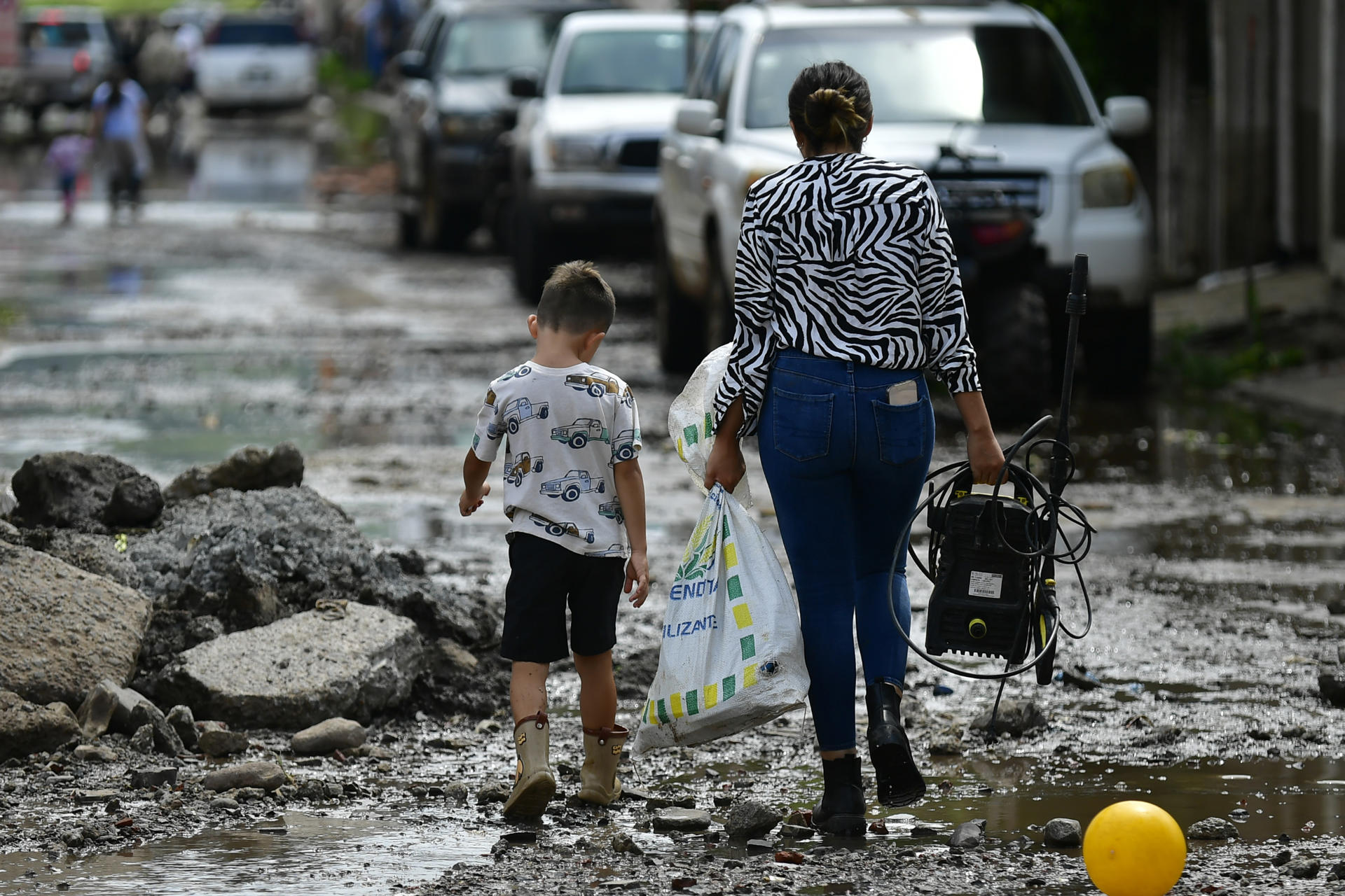 Personas caminan en una zona afectada por una inundación provocada por el desbordamiento del río Tajo en el municipio de Tototlán (México). EFE/ Francisco Guasco