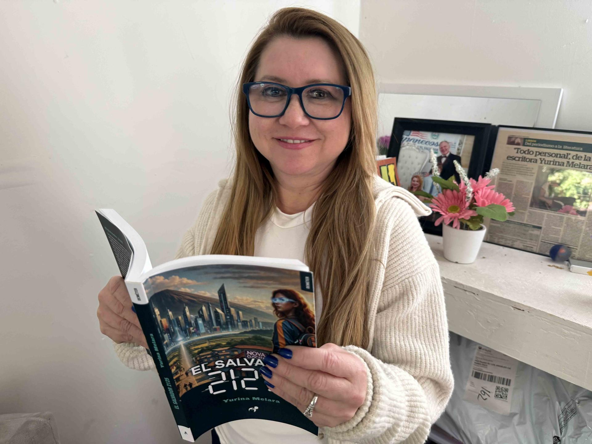 Fotografía cedida de la escritora Yurina Melara sosteniendo una copia de su novela 'El Salvador 2125' en su casa en Los Ángeles (Estados Unidos). EFE/Y. Melara /SOLO USO EDITORIAL /NO VENTAS /SOLO DISPONIBLE PARA ILUSTRAR LA NOTICIA QUE ACOMPAÑA /CRÉDITO OBLIGATORIO