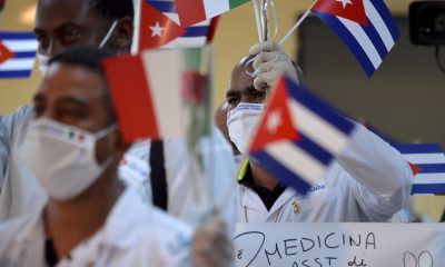 Fotografía de archivo del 8 de junio de 2020 de médicos cubanos de una misión médica ondeando banderas cubanas tras su llegada de Europa a La Habana (Cuba). EFE/ Yamil Lage