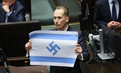 El diputado del partido polaco de extrema derecha Confederación, Konrad Berkowicz, muestra una bandera israelí marcada con una esvástica en el Parlamento polaco en Varsovia, Polonia, el pasado 14 de abril de 2026, cuando acusó a Israel de ser el "nuevo Tercer Reich" y de cometer un genocidio en Gaza. (Polonia, Varsovia) EFE/EPA/RAFAL GUZ POLONIA FUERA