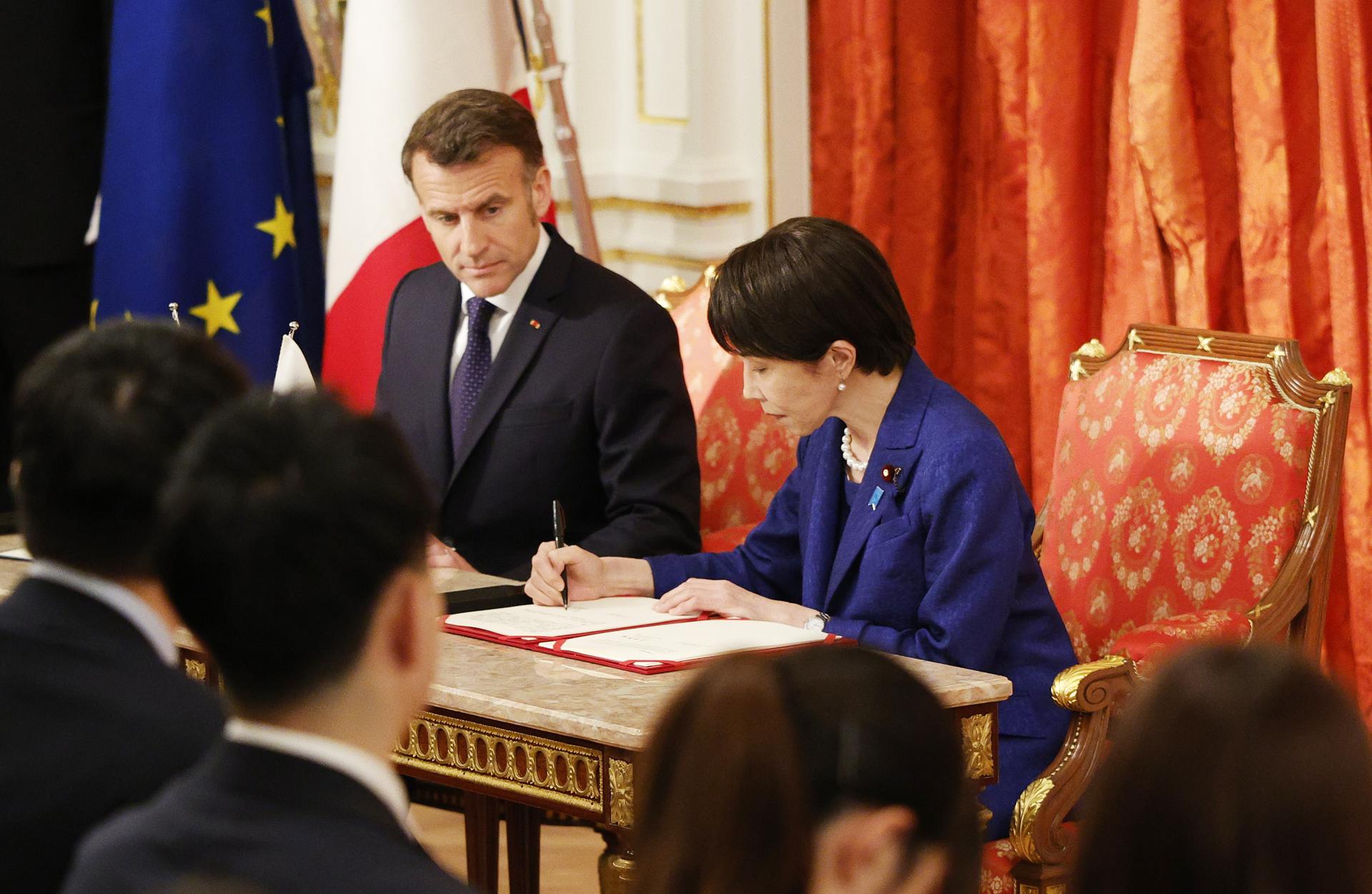 TOKIO (Japón), 01/04/2026.- La primera ministra japonesa, Sanae Takaichi (derecha), firma un documento durante una ceremonia en el Palacio de Akasaka, residencia oficial del gobierno nipón, mientras el presidente francés, Emmanuel Macron (izquierda), observa. EFE/EPA/FRANCK ROBICHON/POOL