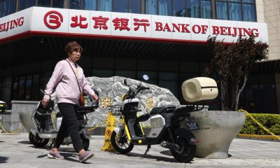 Fotografía tomada el 20/04/2026, que muestra a una mujer caminando frente a una oficina del Banco de Pekín, en China. EFE/EPA/WU HAO