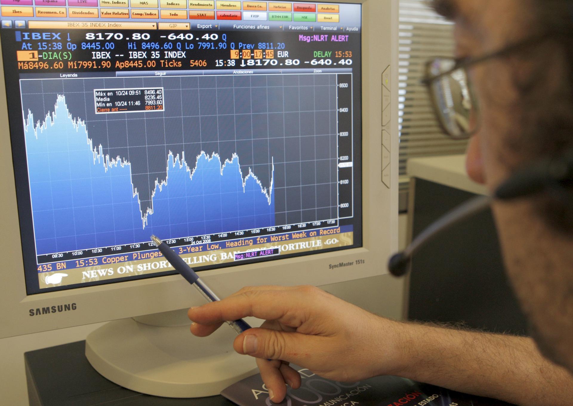 Una persona señala con un bolígrafo en su pantalla de ordenador el comportamiento de un valor del índice Ibex-35 de la Bolsa española. EFE/Chema Moya