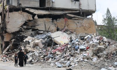 Personas caminan junto a los escombros de un edificio dañado por un ataque aéreo israelí en la aldea de Jibchit, al sur del Líbano, el 21 de abril de 2026. EFE/EPA/WAEL HAMZEH