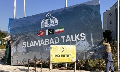Unos trabajadores retiran este domingo una pancarta gigante que anunciaba las negociaciones entre Irán y Estados Unidos, tras la conclusión sin resultado de las mismas en Islamabad. EFE/EPA/SOHAIL SHAHZAD