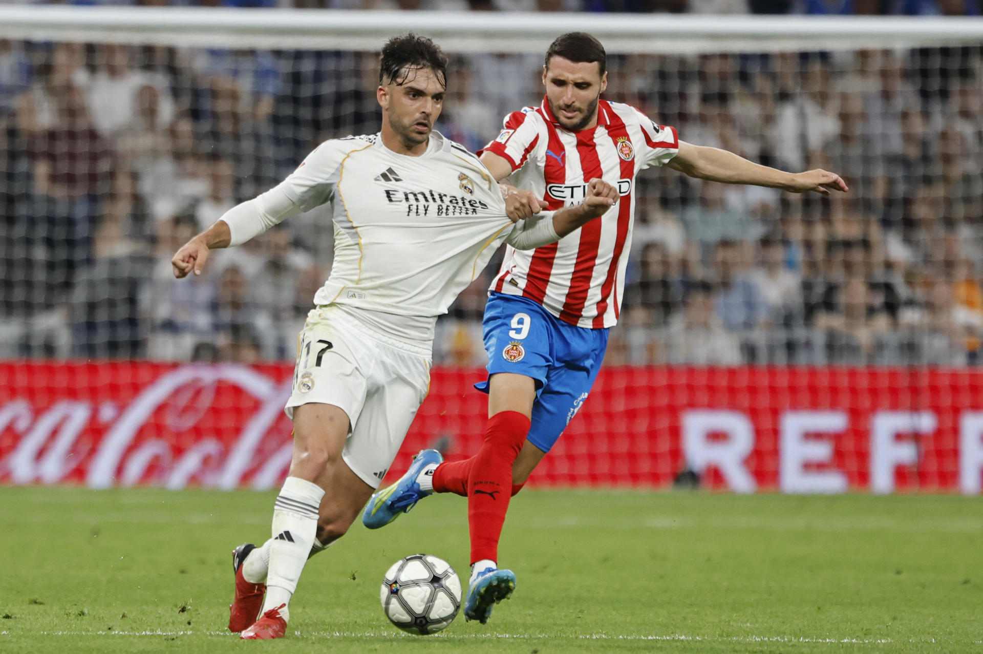 El delantero del Girona Abel Ruiz (d) disputa un balón ante Raúl Asencio, del Real Madrid, durante el partido de la jornada 31 de LaLiga EA Sports que disputaron Real Madrid y Girona FC el viernes 10 de abril. EFE/Sergio Pérez