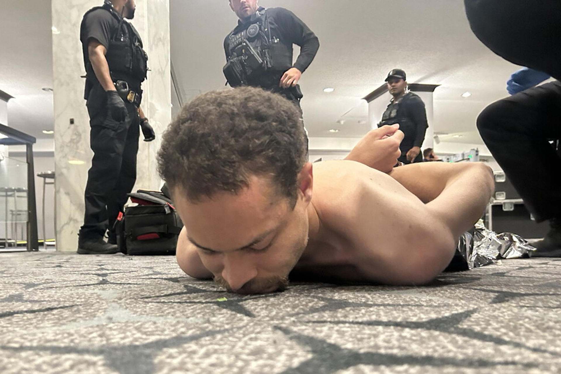 Fotografía difundida en la cuenta oficial @realDonaldTrump de la red social Truth del presidente de los Estados Unidos, Donald Trump, donde se muestra al supuesto tirador arrestado por agentes del Servicio Secreto este sábado, luego de que se reportaran aparentes disparos durante la cena anual de la Asociación de Corresponsales de la Casa Blanca (WHCA) en Washington (Estados Unidos). EFE/ @realDonaldTrump