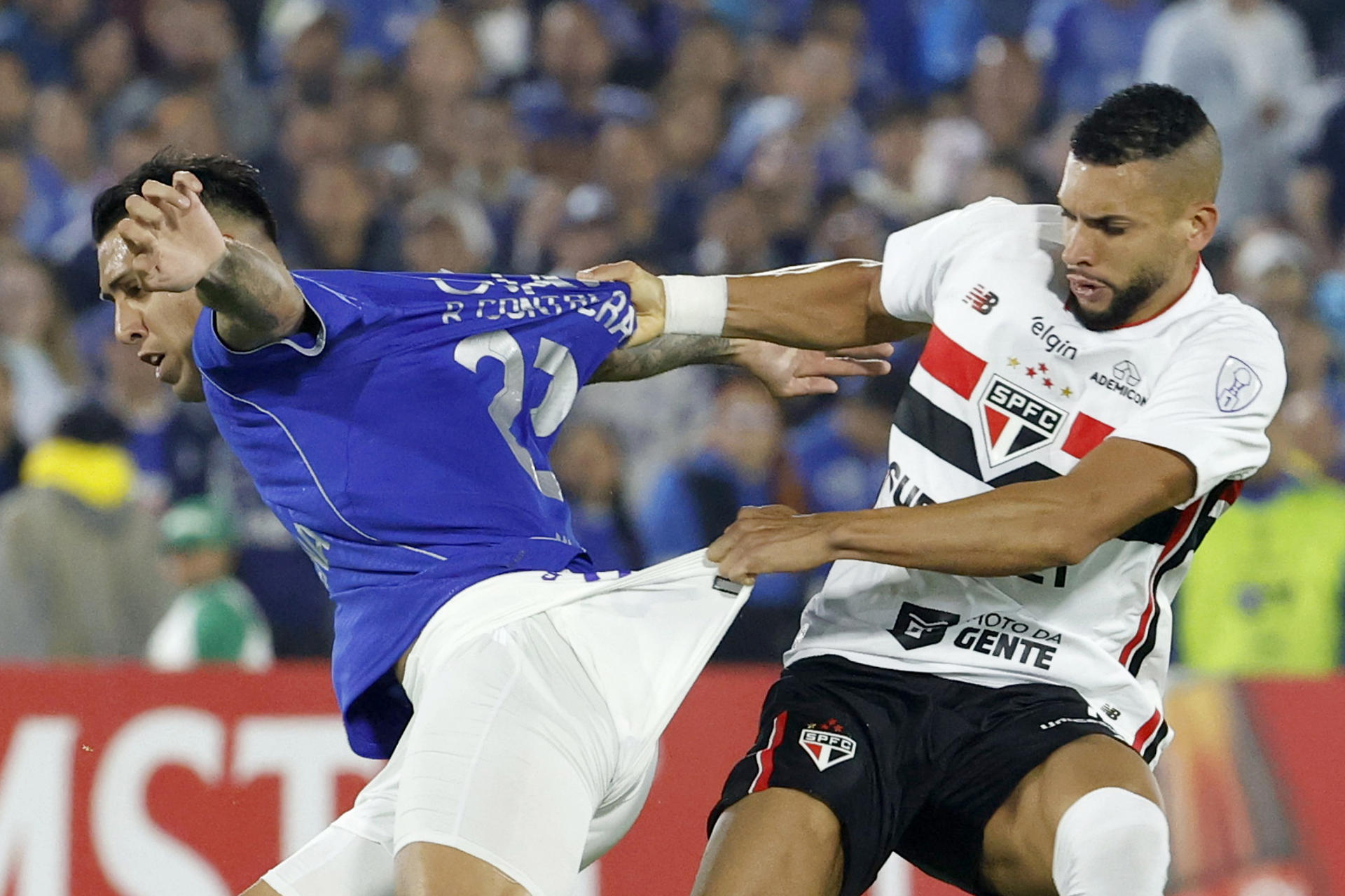El delantero argentino de Millonarios, Rodrigo 'el Tucu' Contreras (i), es marcado a presión por el defensor de Sao Páulo Dória durante el partido de la tercera jornada de la fase de grupos de la Copa Sudamericana jugado este martes en el estadio Nemesio Camacho El Campín de Bogotá. EFE/ Mauricio Dueñas Castañeda