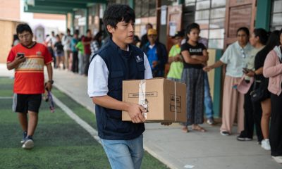Fotografía del lunes 13 de abril de 2026 que muestra a un integrante de la Oficina Nacional de Procesos Electorales (ONPE) que carga una caja para empezar la instalación de una de las mesas de votación en el colegio Señor de los Milagros, en el distrito de Lurín (Perú). EFE/ John Reyes Mejía