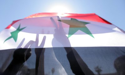 Varias personas ondean banderas sirias. EFE/ Youssef Badawi