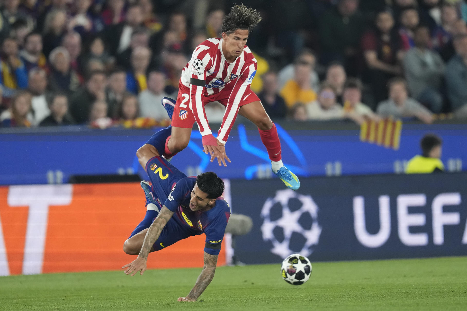 El centrocampista argentino del Atlético de Madrid, Giuliano Simeone, salta ante el defensa portugués del FC Barcelona, Cancelo, durante el encuentro correspondiente a la ida de los cuartos de final de la Liga de Campeones que disputaron FC Barcelona y Atlético de Madrid en el estadio Camp Nou, en Barcelona. EFE / Enric Fontcuberta.