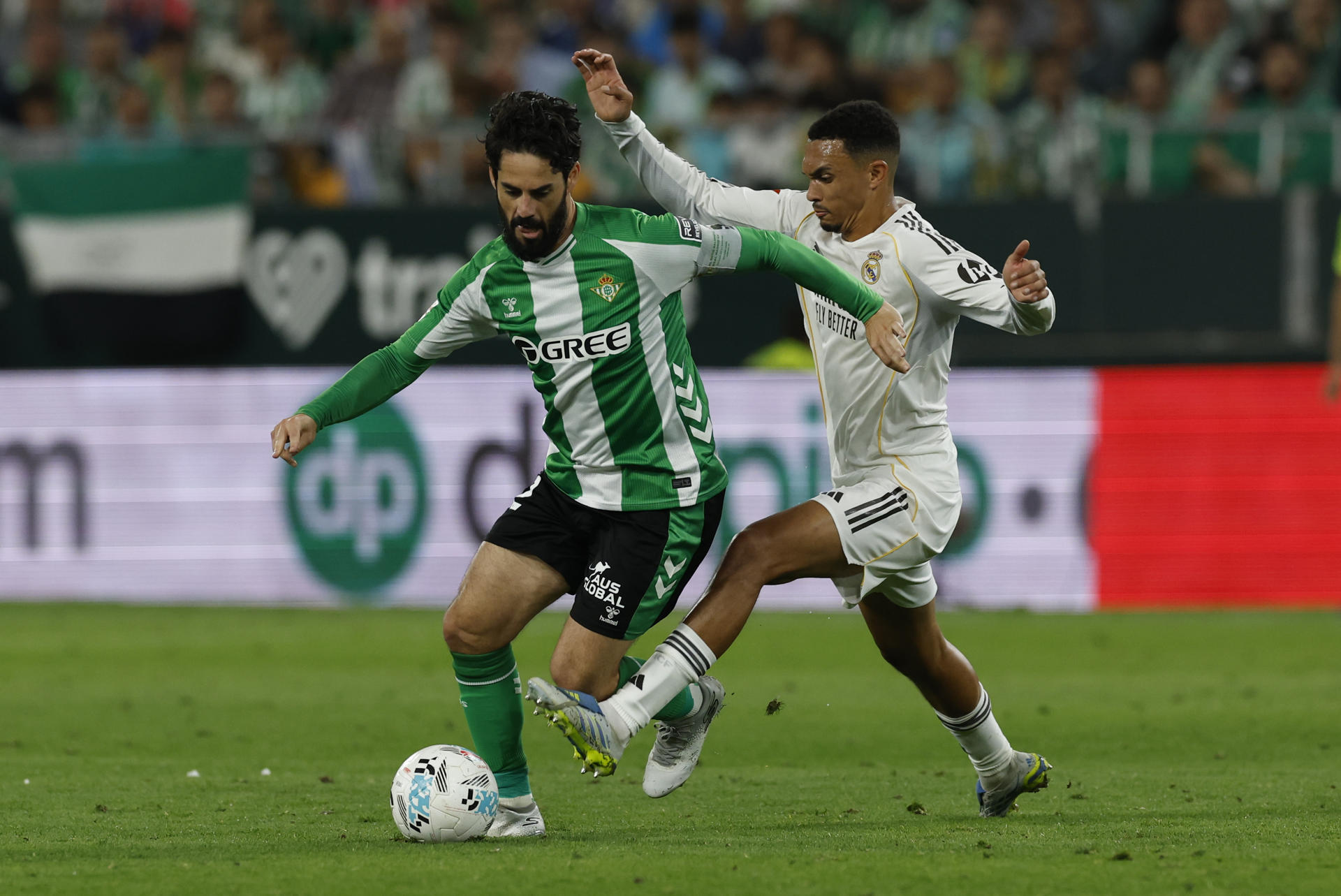 El centrocampista del Betis, Isco (i), intenta llevarse el balón ante el defensa británico del Real Madrid, Trent Alexander-Arnold, durante el encuentro correspondiente a la jornada 32 de LaLiga que disputan Real Betis y Real Madrid este viernes en el estadio de La Cartuja, en Sevilla. EFE/ Julio Muñoz.