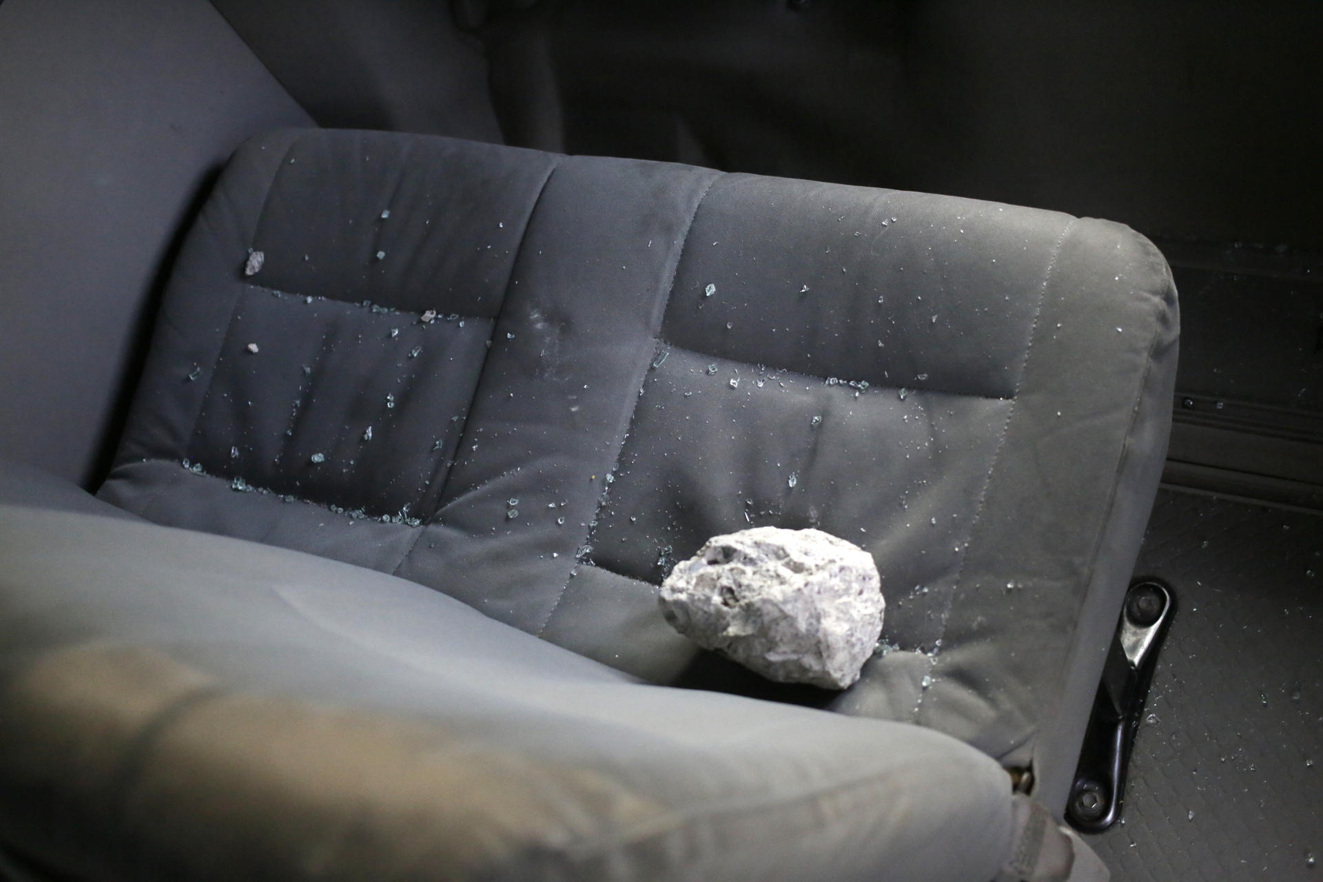 Una roca cayó dentro de un vehículo durante los enfrentamientos entre fanáticos de los equipos Motagua y Olimpia en Tegucigalpa (Honduras). EFE/Gustavo Amador