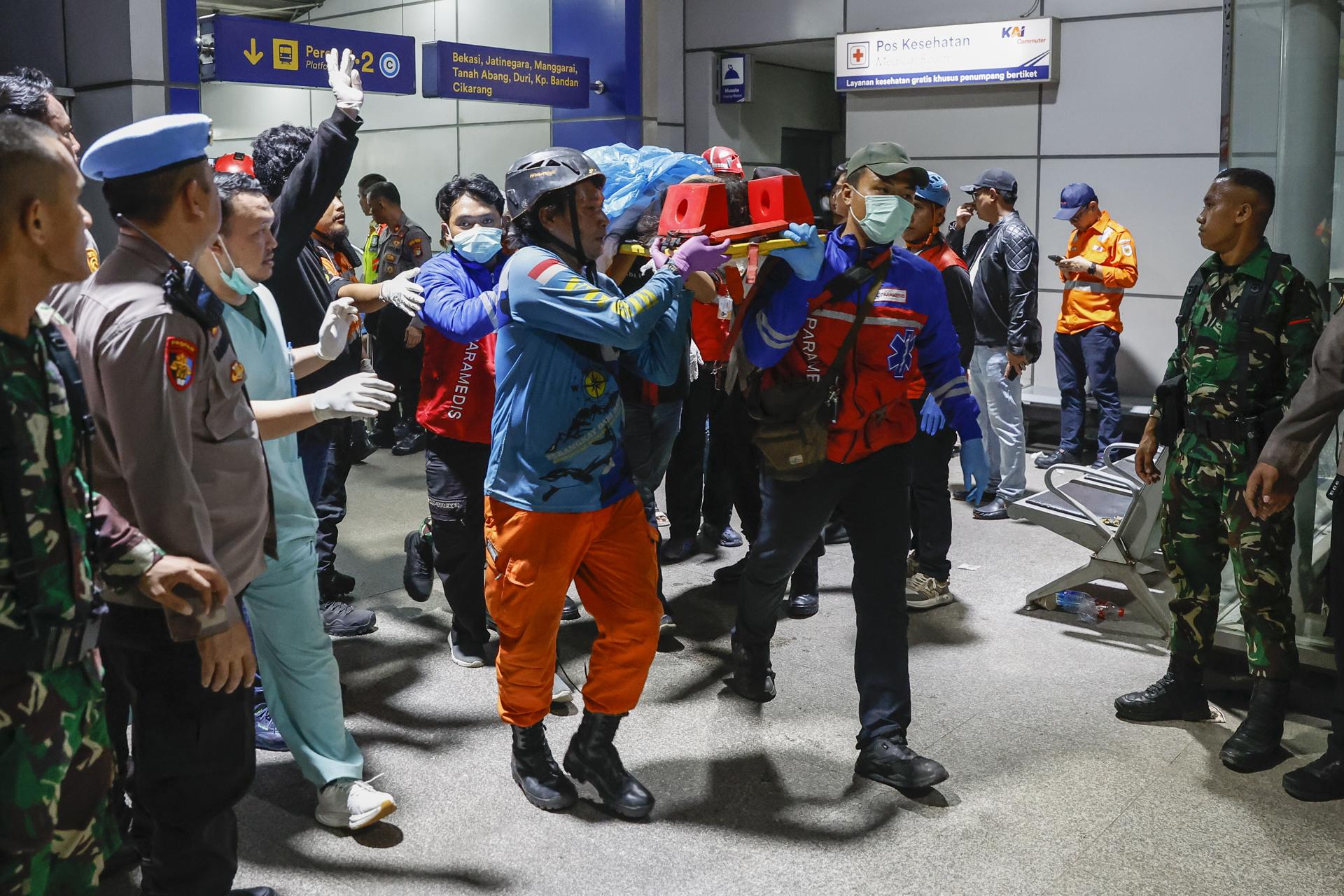 BEKASI (Indonesia), 27/04/2026.- Rescatistas trasladan a una ambulancia el cuerpo de una víctima del letal choque de trenes en la estación de tren de East Bekasi. EFE/EPA/MAST IRHAM