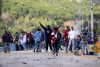 Personas se enfrentan con integrantes de la Policía Nacional dominicana este domingo, en San Juan de la Maguana (República Dominicana). EFE/ Orlando Barría
